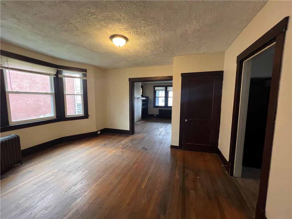 216 Suncrest Street Pittsburgh, PA 15210 - Photo 11 of 32 an empty room with wooden floor and windows