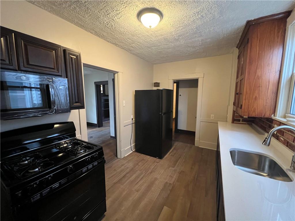 216 Suncrest Street Pittsburgh, PA 15210 - Photo 14 of 32 a kitchen with a refrigerator stove and cabinets