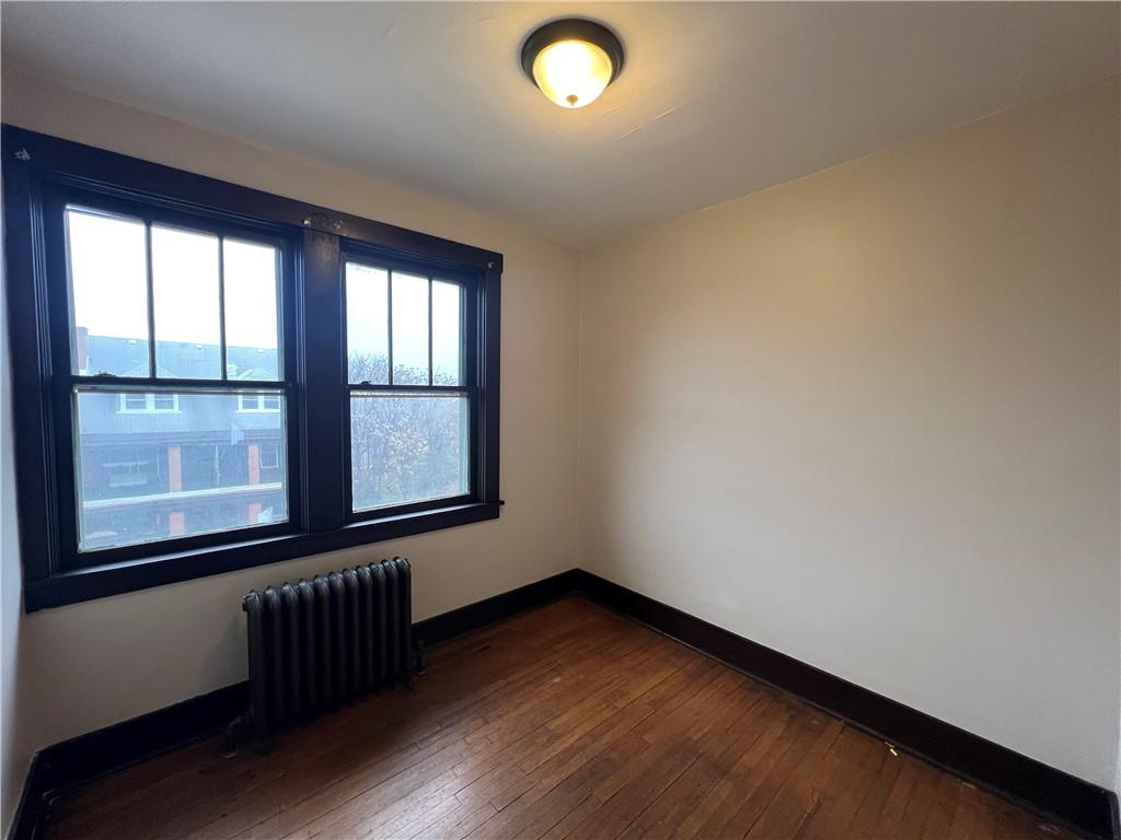 216 Suncrest Street Pittsburgh, PA 15210 - Photo 17 of 32 an empty room with wooden floor and windows