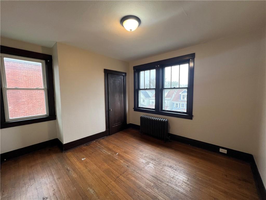 216 Suncrest Street Pittsburgh, PA 15210 - Photo 19 of 32 an empty room with wooden floor and windows