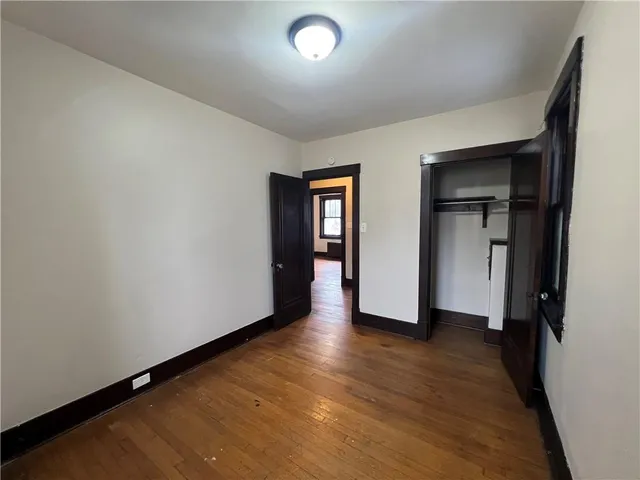 an empty room with closet and wooden floor