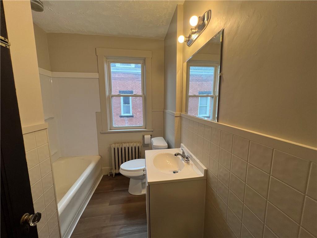 216 Suncrest Street Pittsburgh, PA 15210 - Photo 24 of 32 a bathroom with a sink a mirror and a bathtub