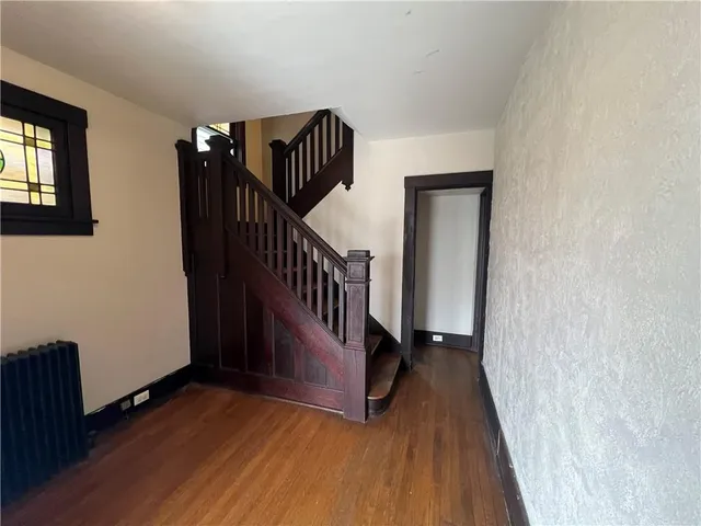 a view of a hallway with wooden floor and stairs