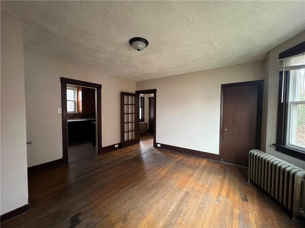 216 Suncrest Street Pittsburgh, PA 15210 - Photo 10 of 32 a view of an empty room with wooden floor and a window