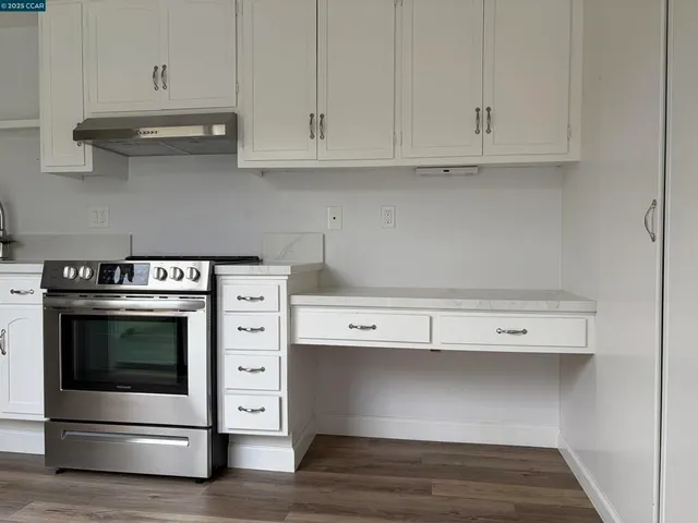 a kitchen with white cabinets and a stove