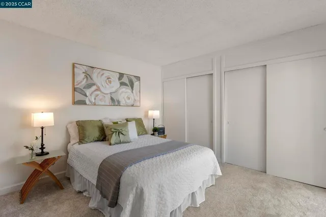 a bedroom with a bed and a lamp on dresser