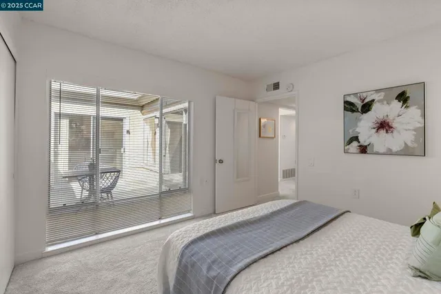 a bedroom with a bed and glass door