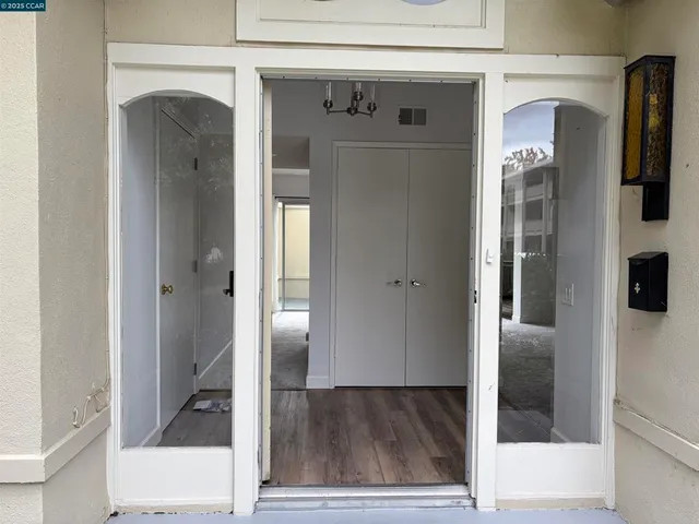 a view of a hallway with wooden floor and staircase