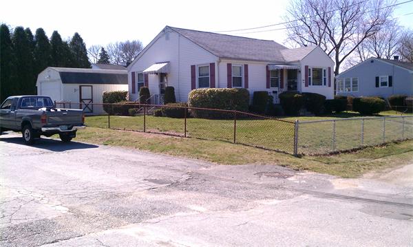 83 Lepes Road Tiverton, RI 02878 - Photo 3 of 5 a front view of a house with a yard and garage