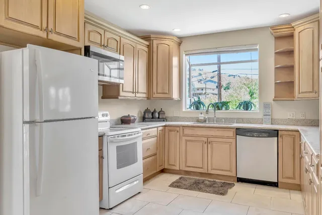 a kitchen with white cabinets and sink
