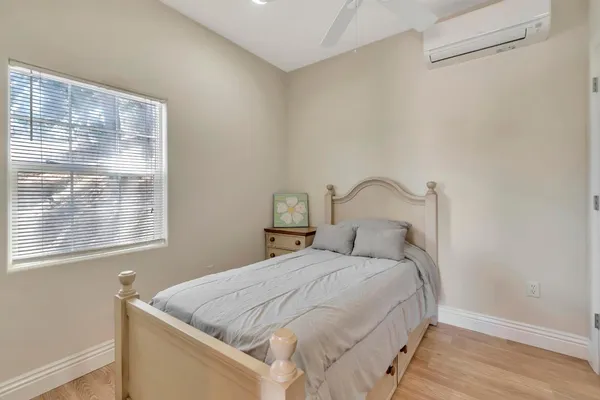 a view of an empty room with wooden floor and windows