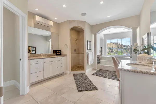 a spacious bathroom with a granite countertop sink and a mirror