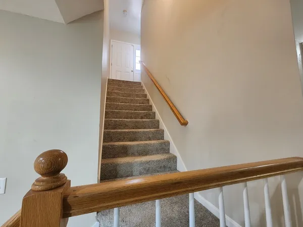 a view of a hallway with wooden floor and staircase