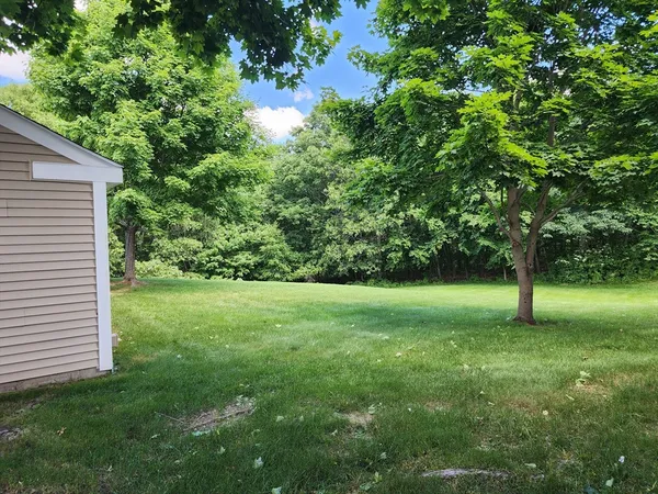 a view of a house with backyard and sitting area