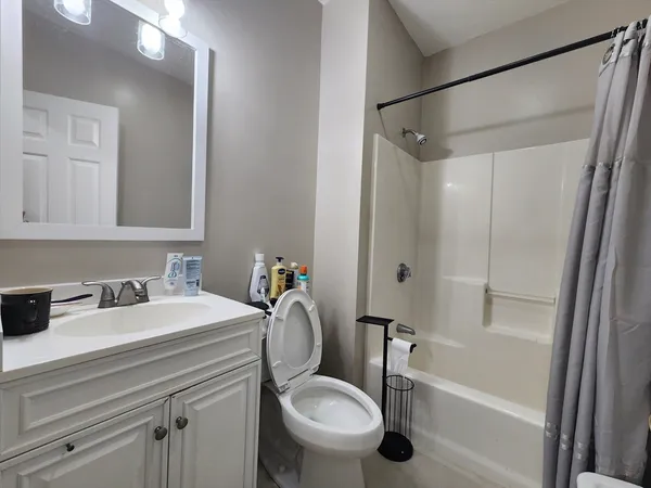 a bedroom with a bed and a flat tv screen on dresser