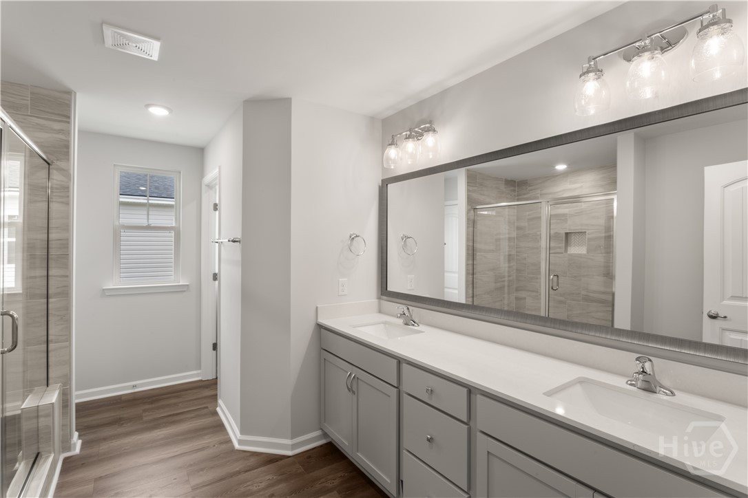 29 Blues Drive Pooler, GA 31322 - Photo 31 of 40 Primary bathroom features double vanities w/ a quartz top, framed mirror, and a large 6' tiled shower-only with a bench! Private water closet.