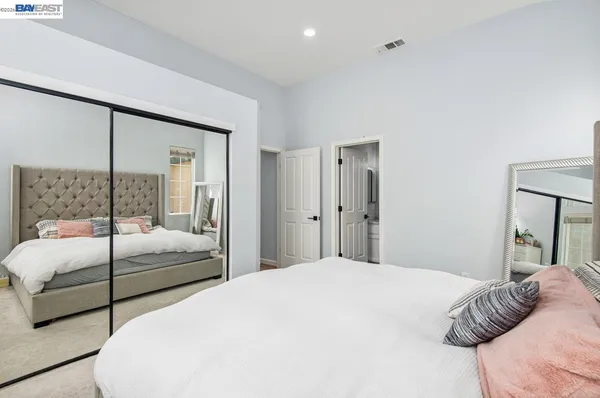 a bedroom with a large bed and a large mirror