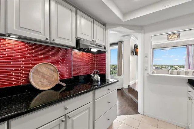 a kitchen with granite countertop a sink cabinets and a window