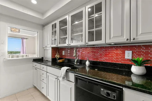 a kitchen with granite countertop cabinets stove top oven and microwave