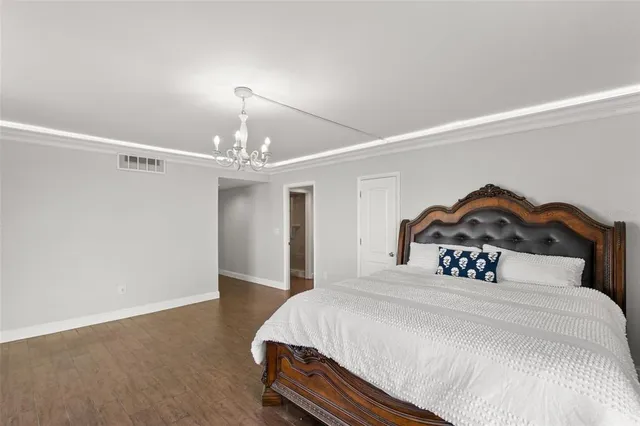 a bedroom with a bed and a chandelier
