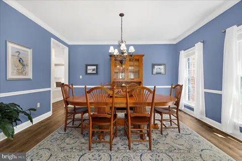 a dining room with furniture a chandelier and wooden floor