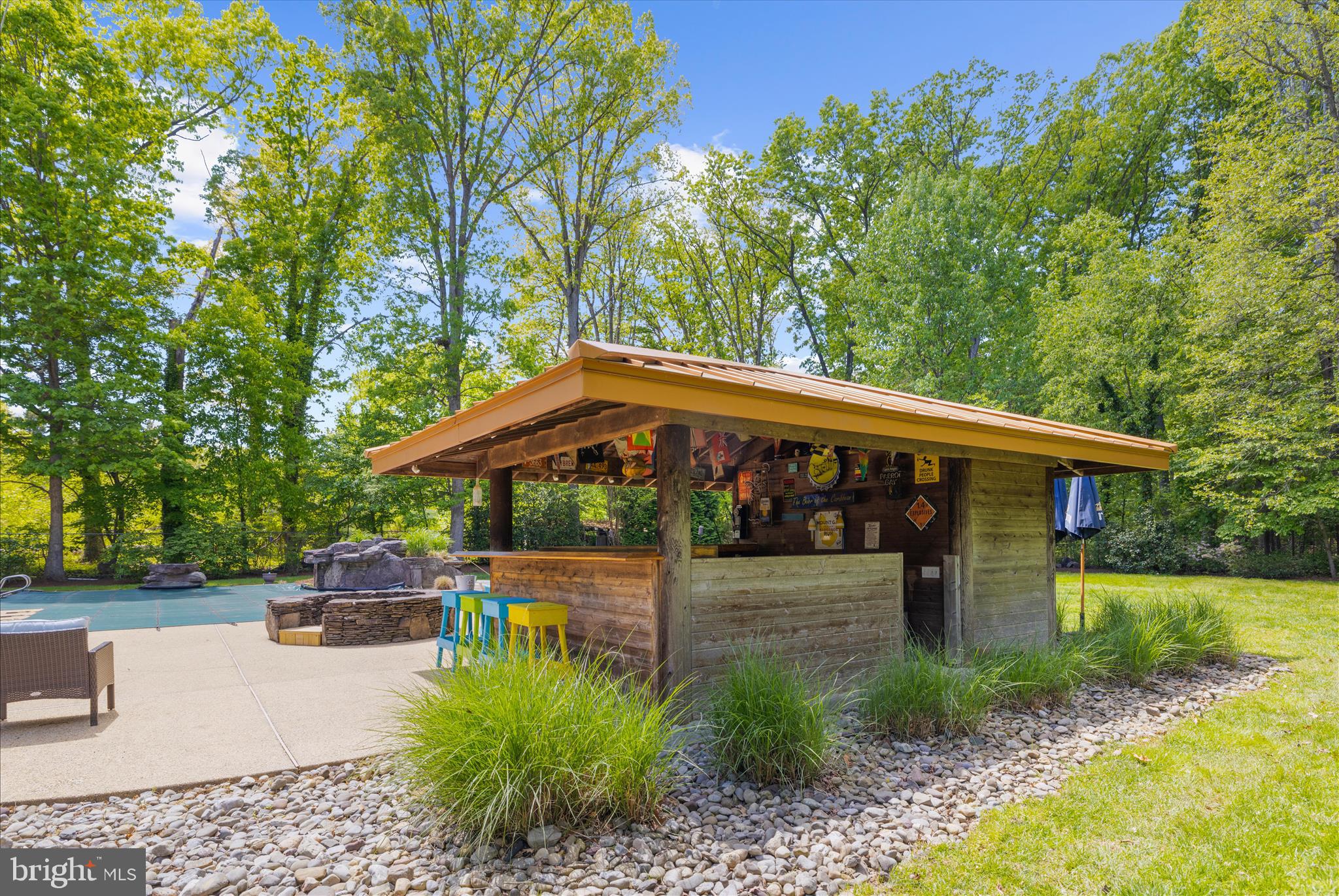 470 Jumpers Hole Road Severna Park, MD 21146 - Photo 55 of 72 a view of a patio with table and chairs under an umbrella with large trees