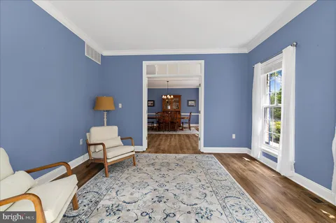 a view of a hallway with wooden floor and windows