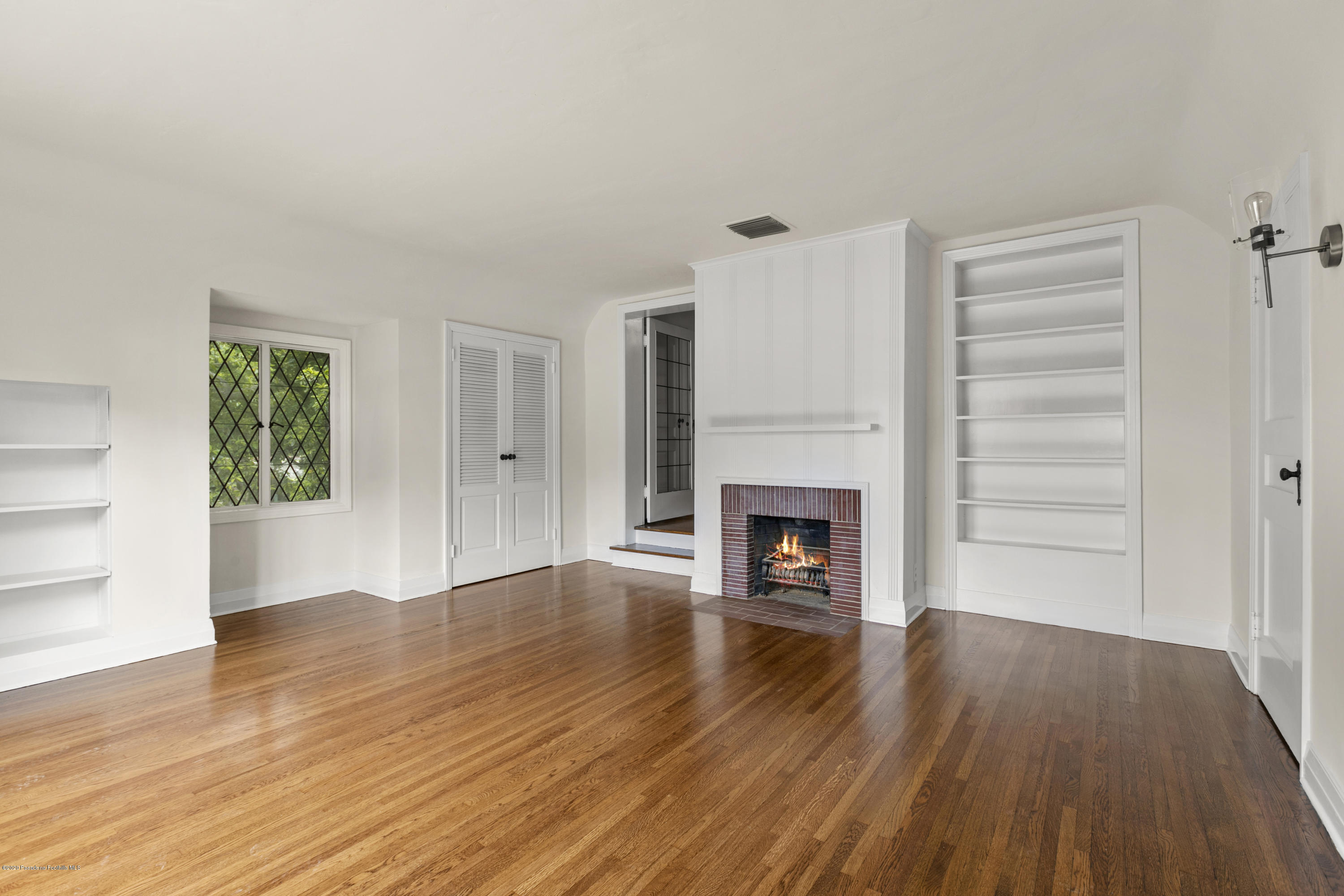 1701 East Altadena Drive Altadena, CA 91001 - Photo 27 of 36 an empty room with wooden floor fireplace and windows