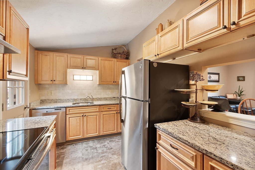 425 Main Street, Unit 8B Hudson, MA 01749 - Photo 12 of 31 a kitchen with a sink refrigerator and cabinets
