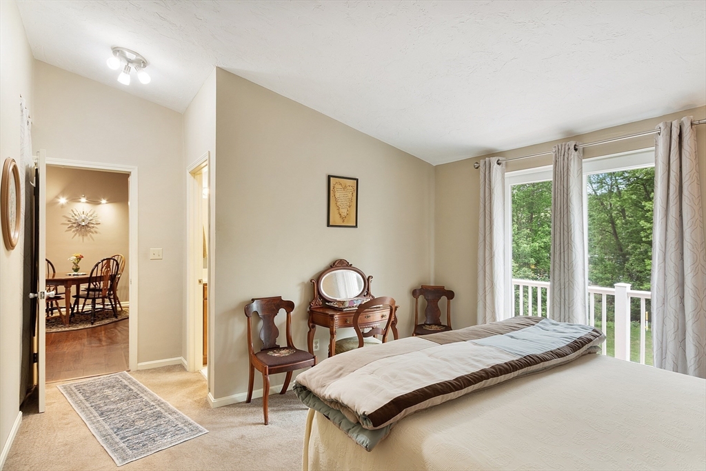 425 Main Street, Unit 8B Hudson, MA 01749 - Photo 15 of 31 a bedroom with a bed and a table with mirror