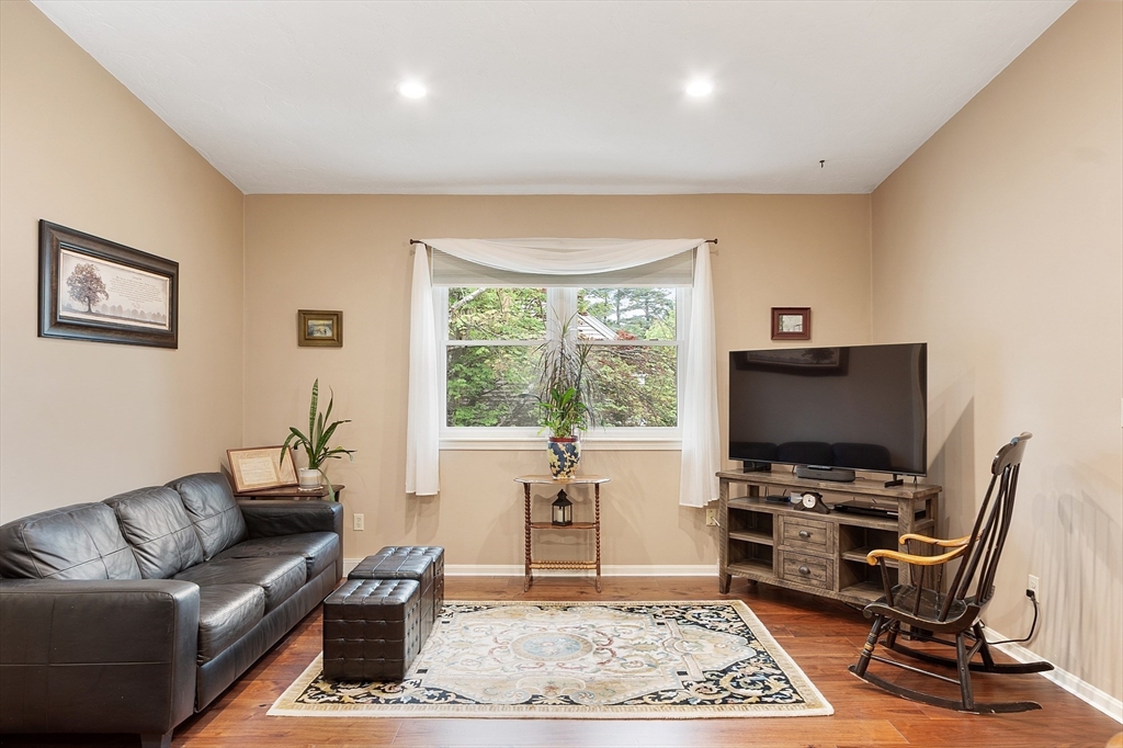 425 Main Street, Unit 8B Hudson, MA 01749 - Photo 5 of 31 a living room with furniture and a flat screen tv