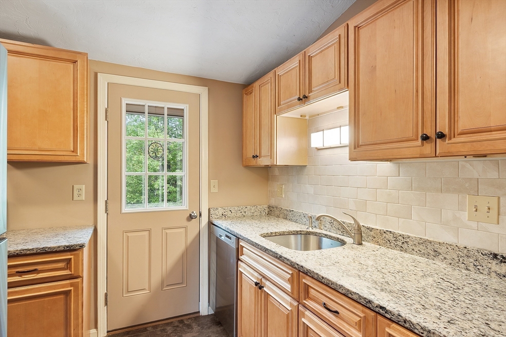 425 Main Street, Unit 8B Hudson, MA 01749 - Photo 9 of 31 a view of a kitchen with granite countertop cabinets washer and dryer