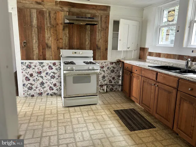a kitchen with a stove top oven and cabinets