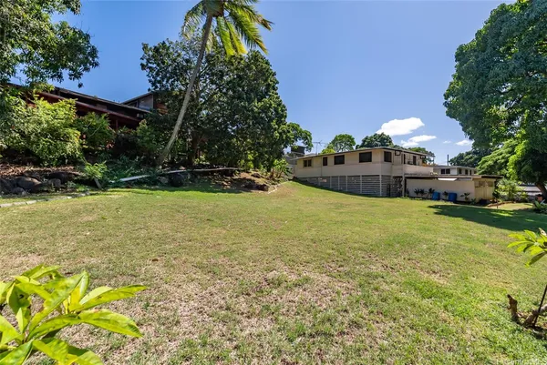an aerial view of a house with a yard and trees