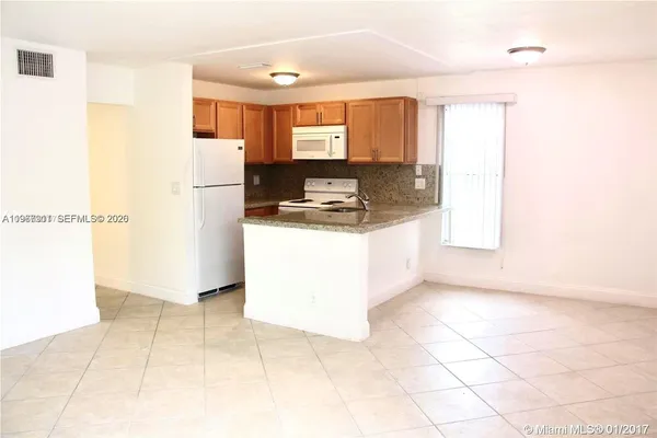 a kitchen with a refrigerator a stove a sink and a counter