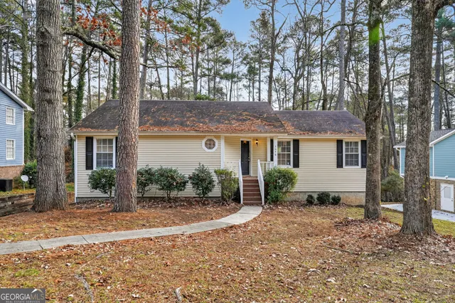 a view of a house with a yard and large tree