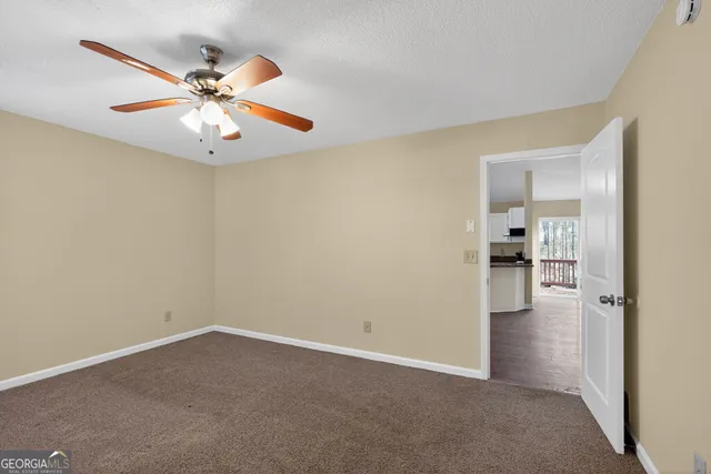 an empty room with closet and a chandelier fan