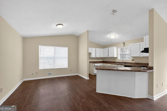 a kitchen with stainless steel appliances granite countertop a stove a sink and a microwave