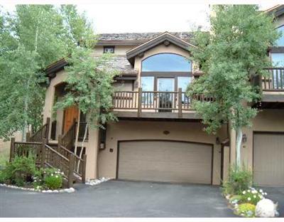 152 Knudson Ranch Road, Unit 152 Edwards, CO 81632 - Photo 3 of 6 a front view of a house with a yard and garage