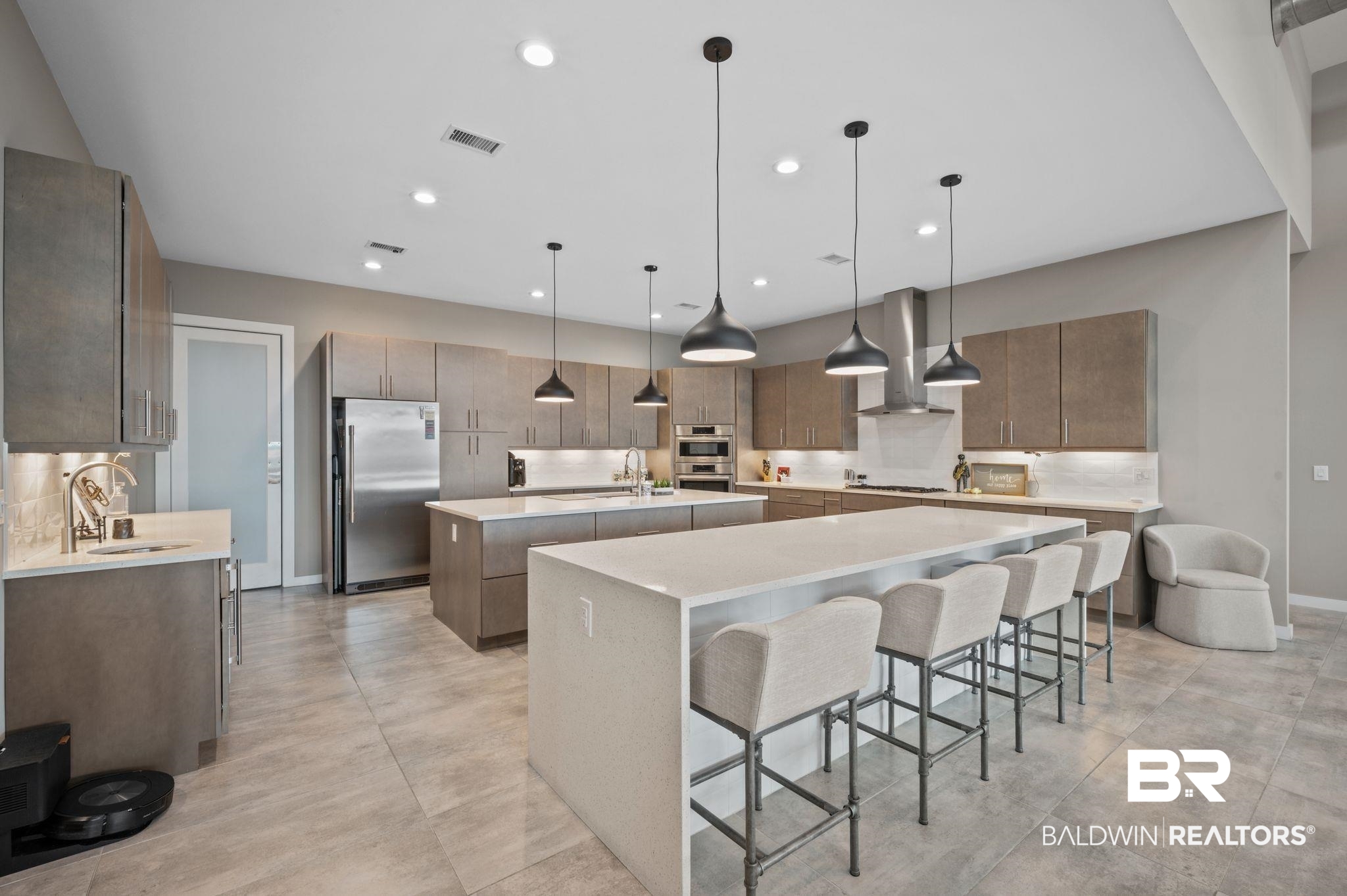 3840 Cotton Way Orange Beach, AL 36561 - Photo 12 of 75 Kitchen featuring pendant lighting, a large island with sink, wall chimney range hood, sink, and stainless steel appliances