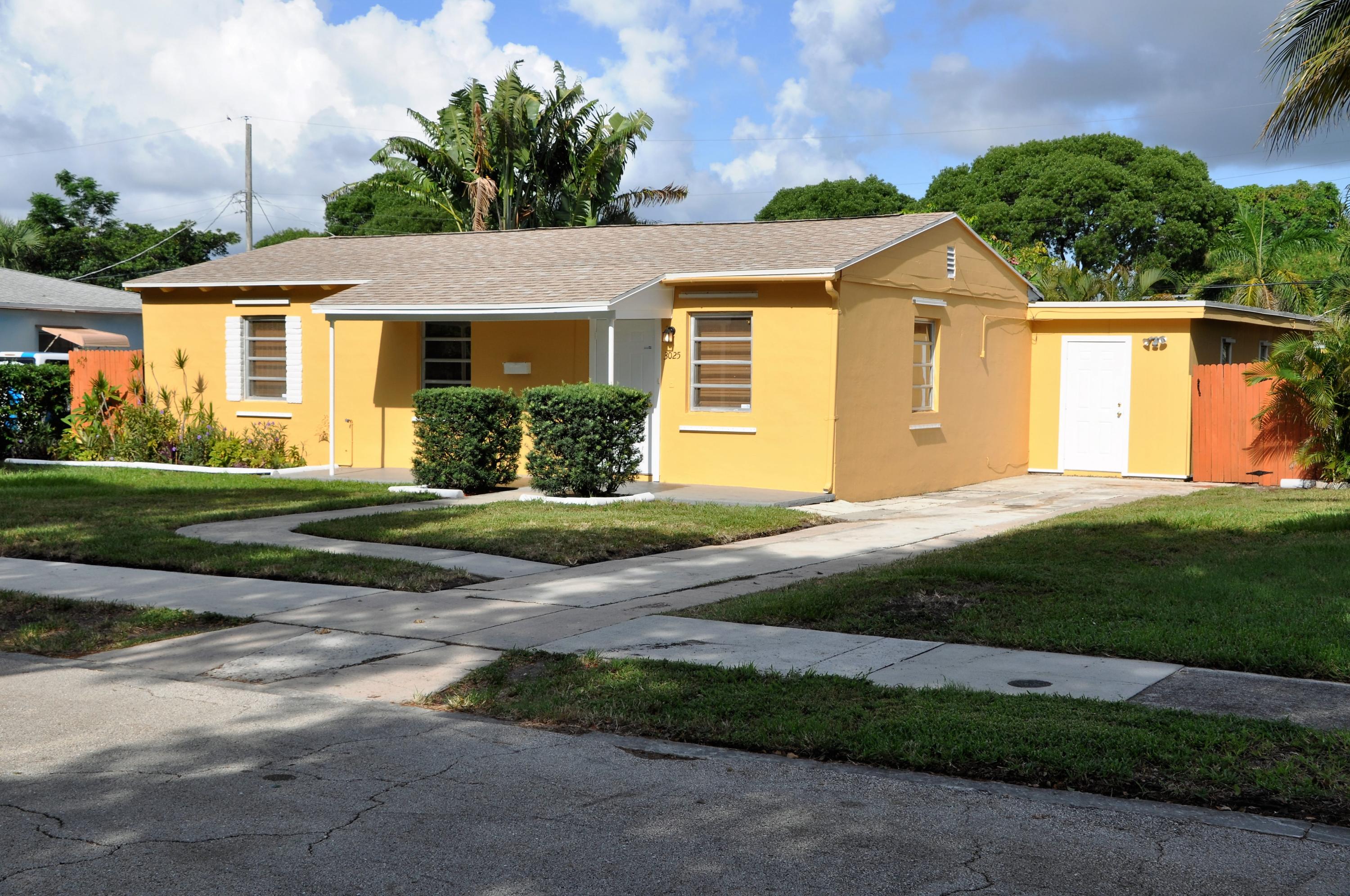 3025 Robert Road West Palm Beach, FL 33405 - Photo 1 of 41 a front view of a house with a yard