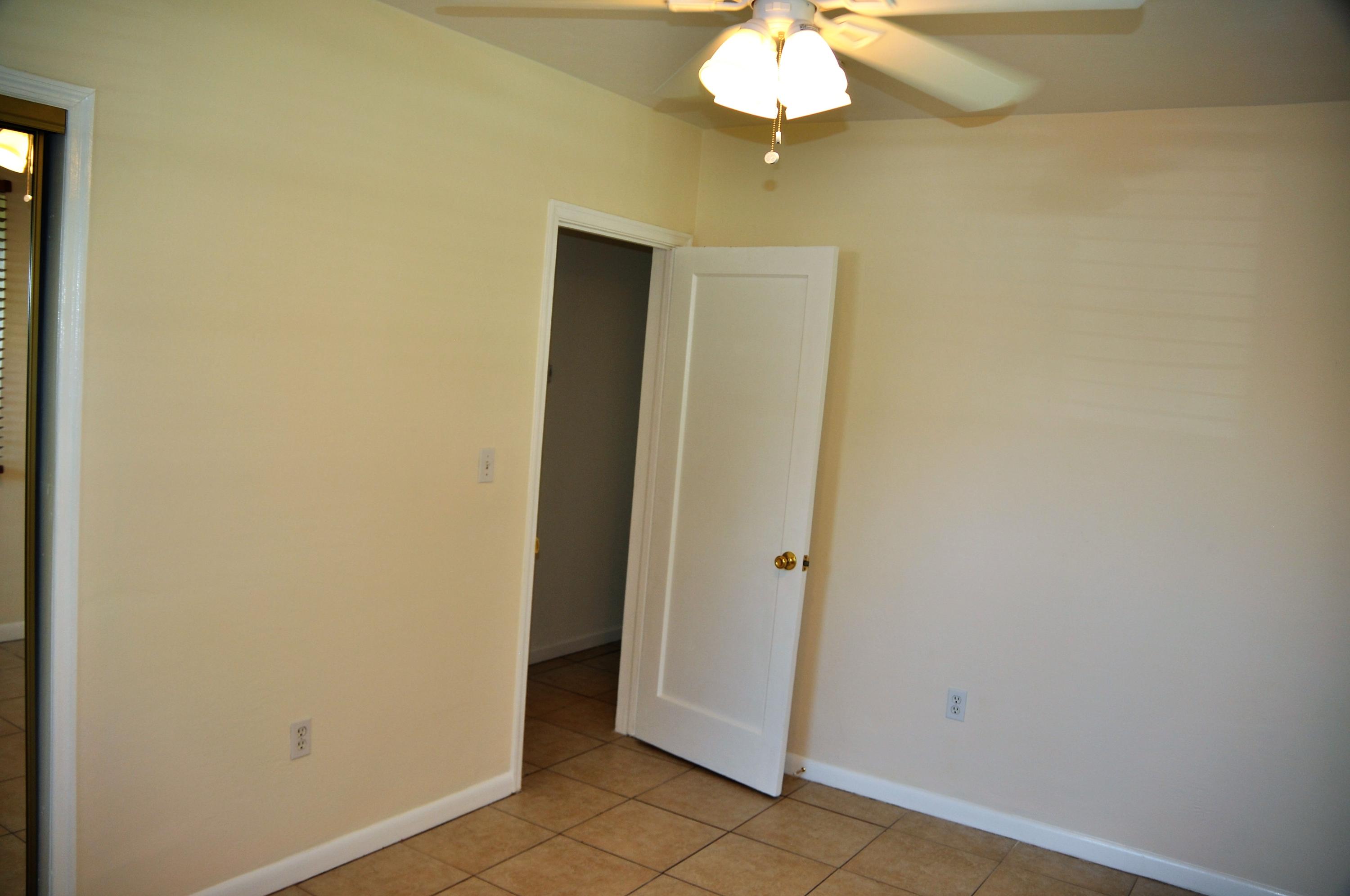 3025 Robert Road West Palm Beach, FL 33405 - Photo 32 of 41 an empty room with a chandelier fan and glass door