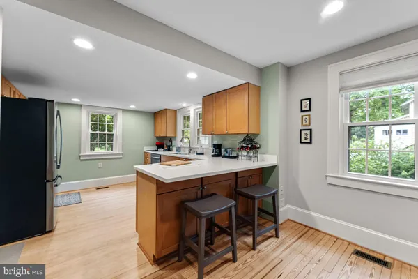 a kitchen with stainless steel appliances granite countertop a sink a stove cabinets counter space and a window
