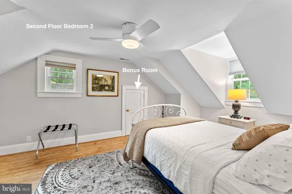 a bedroom with a large bed and wooden floor