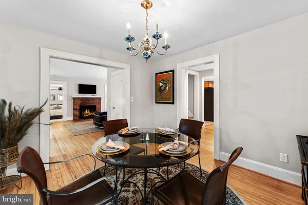 a dining room with furniture a chandelier and wooden floor