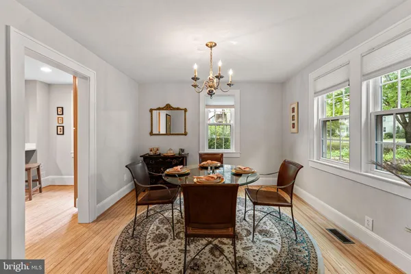 a kitchen with stainless steel appliances granite countertop a table chairs refrigerator and sink