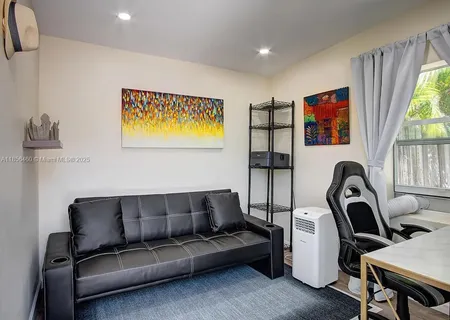 a living room with furniture a flat screen tv and a large window