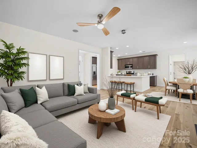 a living room with furniture kitchen view and a potted plant