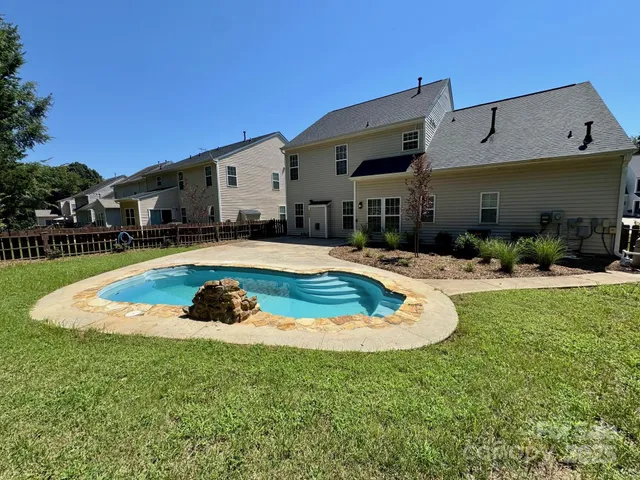 a swimming pool with outdoor seating and yard
