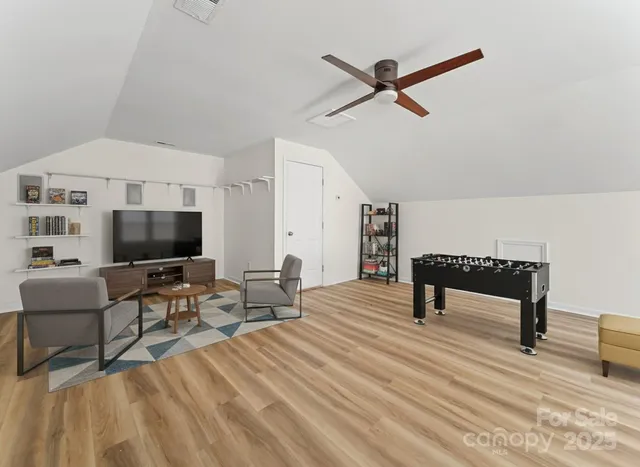 a view of a livingroom with wooden floor and a ceiling fan